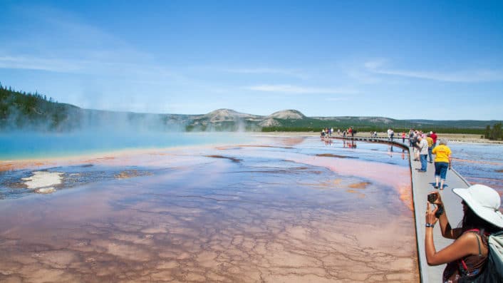 Tourists Snap Photos Of The Rainbow Colors Of The GrandP Prismatic Spring In Yellowstone National Park