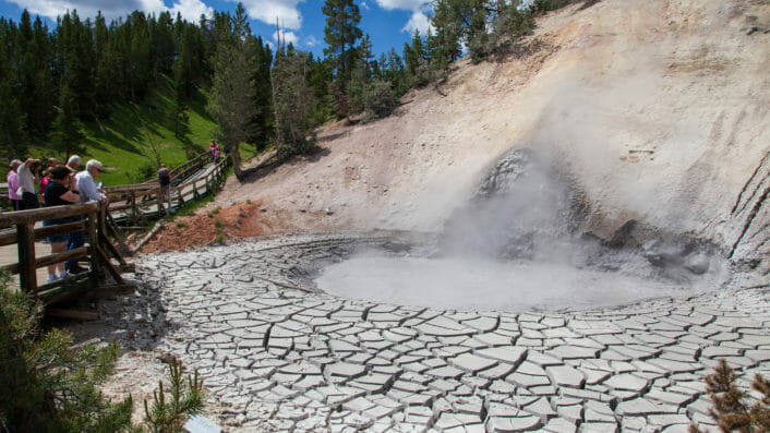 A Giant Mud Pot Bubbles While Tourist Watch Safely From The Boardwalk In Yellowstone National Park
