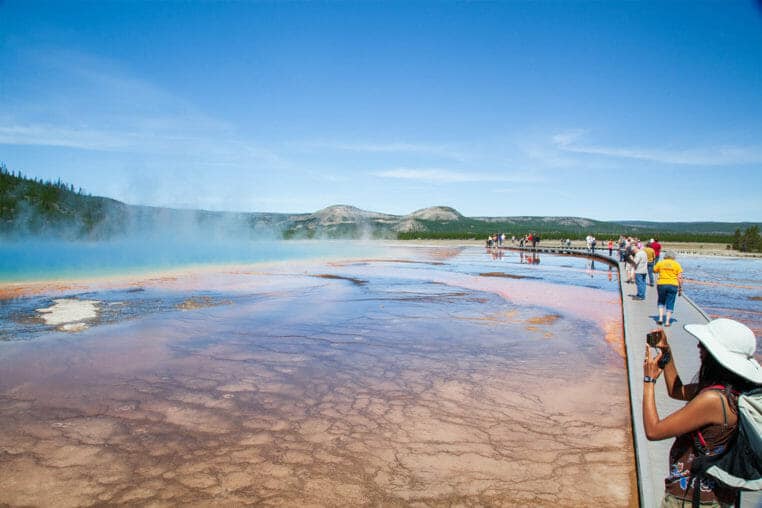 Visitors Stop Along The Boardwalk To Take Photos Of The Grand Prismatic Spring At The Midway Geyser Basin In Yellowstone National Park