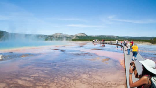 Tourists Capture Photos Of The Rainbow Colors Of The Grand Prismatic Spring In Yellowstone National Park