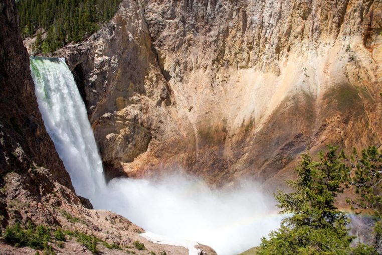 The Lower Falls Of The Yellowstone River Pours Into The Grand Canyon Of The Yellowstone Creating A Rainbow In The Rising Mist