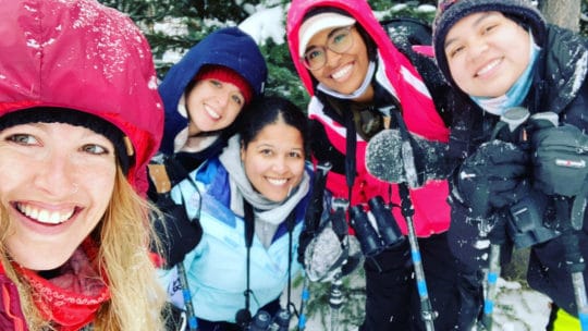 A Group Of Snowshoers Pose With Their Guide While Out On A Snowshoe Safari Tour Near Yellowstone National Park