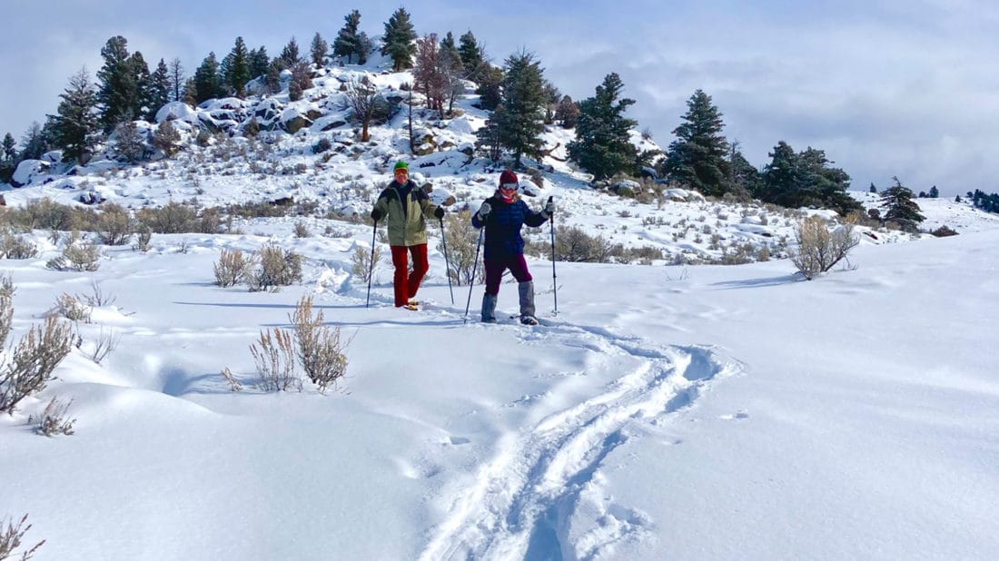A Couple Makes Their Way Along A Snowshoe Trail In The Montana Backcountry