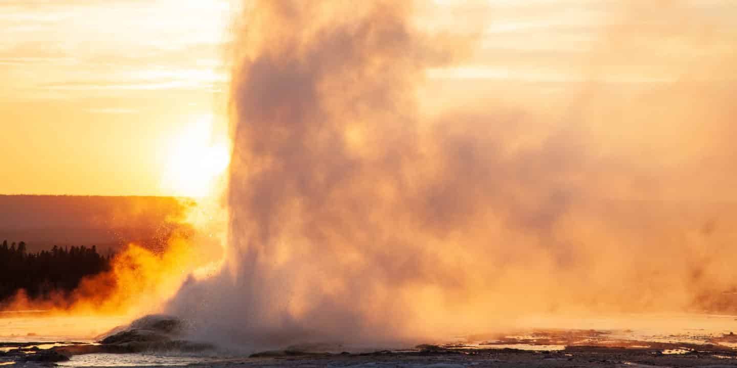 A Geyser Erupts Against the Dusky Backdrop of the Setting Sun in Yellowstone National Park