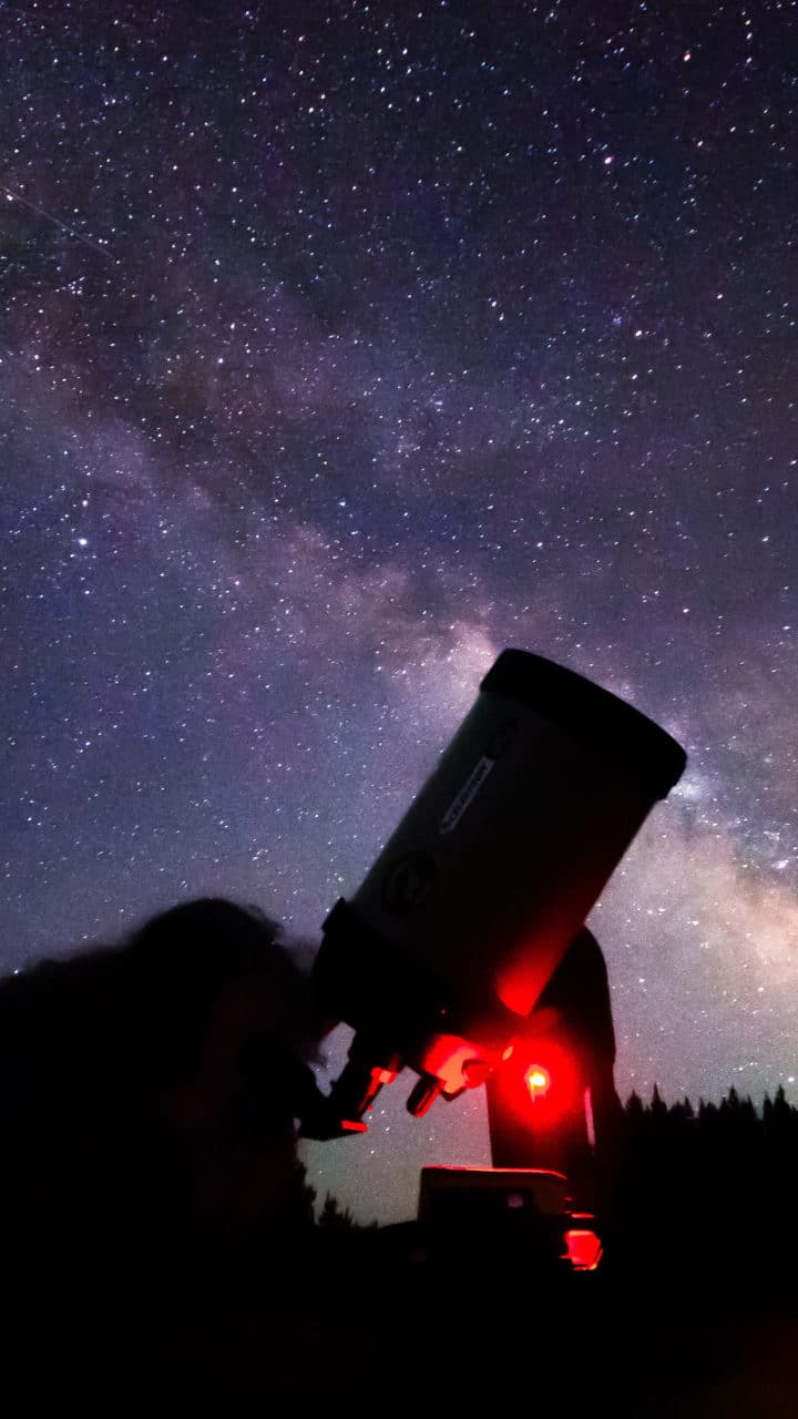 A Professional Astronomer Guide Refines Telescope Settings To Observe The Milky Way In Yellowstone National Park